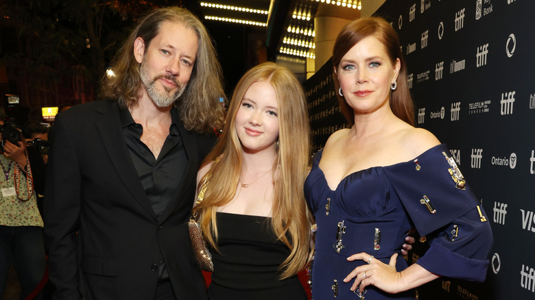 Amy Adams posing with her husband and daughter