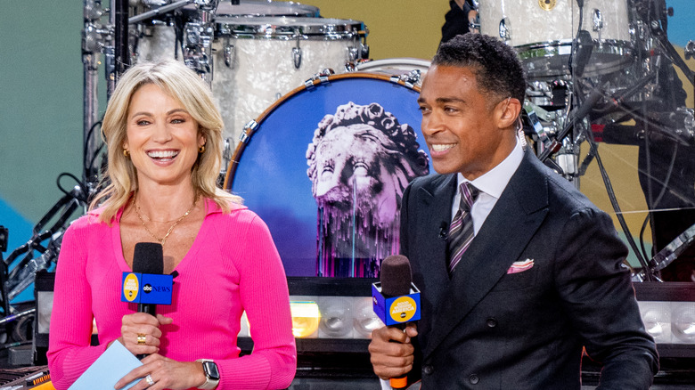 T.J. Holmes and Amy Robach holding microphones