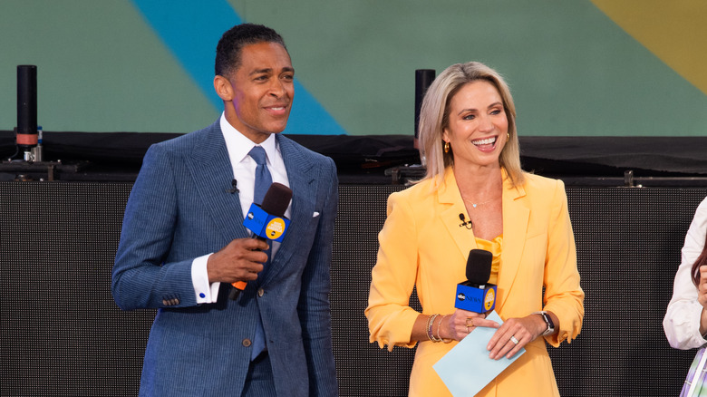 T.J. Holmes and Amy Robach holding microphones