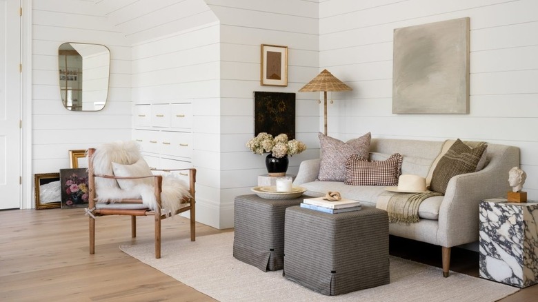 Sitting area with couch, chair, various home decor and white shiplab