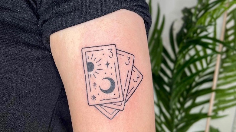 A 333 tattoo worked into tarot card imagery