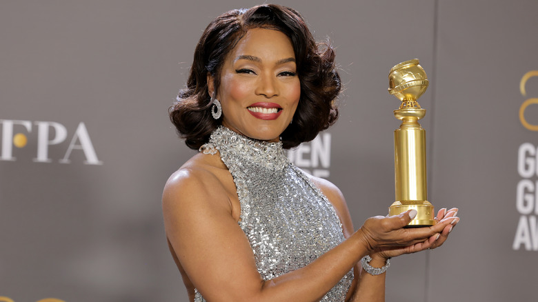 Angela Bassett posing with her Golden Globe award 