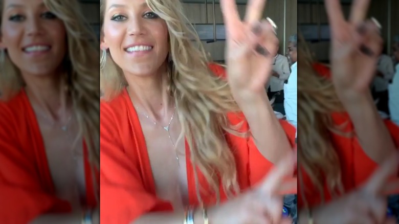 Anna Kournikova giving piece sign in red dress