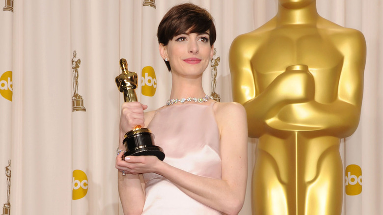 Anne Hathaway holding her Oscar