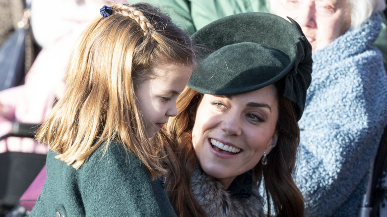 Princess Charlotte smiling at Kate Middleton talking to her