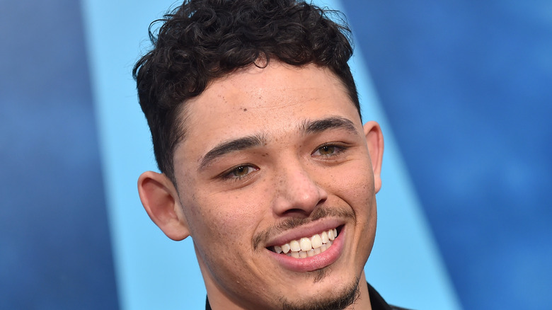 Anthony Ramos smiling blue background