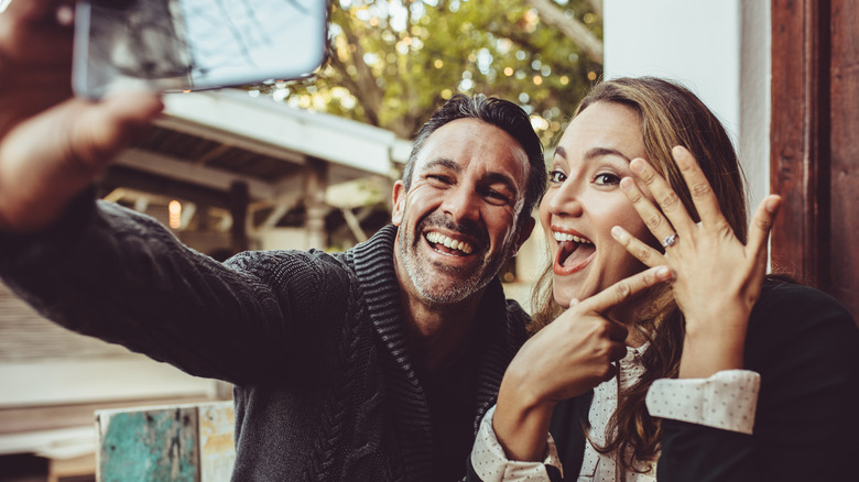 Newly engaged couple taking selfie