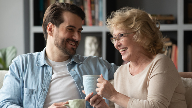 older woman and middle aged man laughing on couch