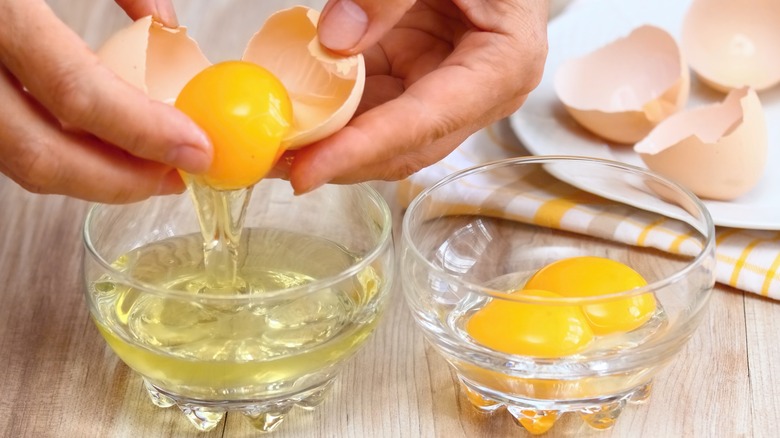 person separating egg whites from yolks