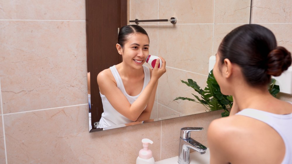 Woman using facial cleansing brush