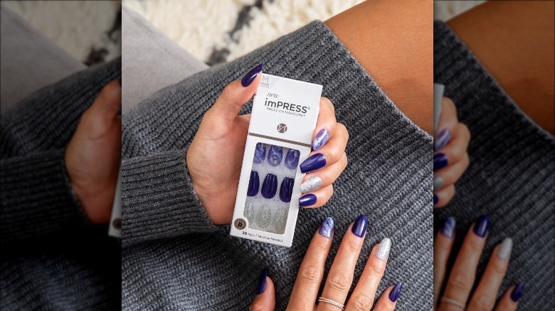 Woman wearing blue and white designed press on nails from Impress