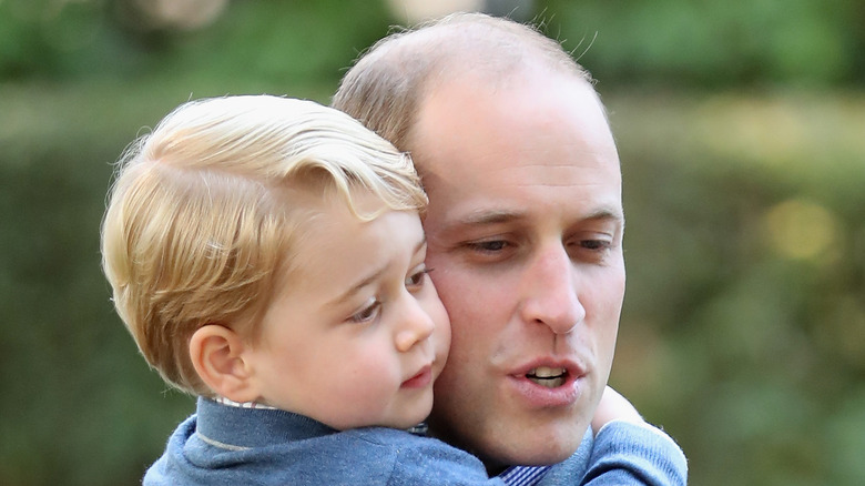 Prince William cuddles Prince George