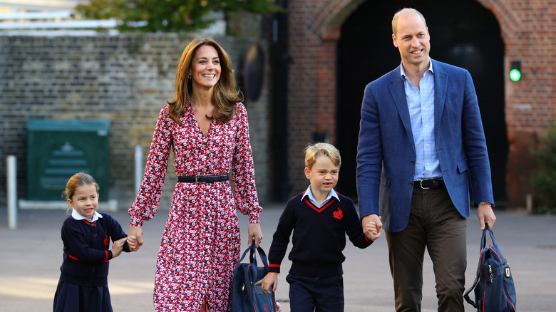 Princess Charlotte and Prince George hold their parents hands