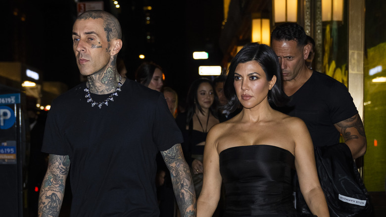 Travis Barker and Kourtney Kardashian hold hands.