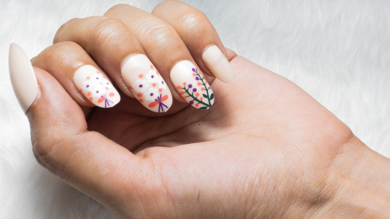 A woman with press-on nails with flowers