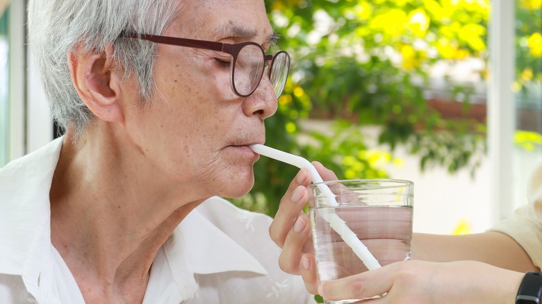 Elderly person sipping on a straw.