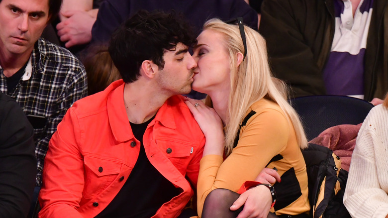 Joe Jonas and Sophie Turner kissing at a basketball game