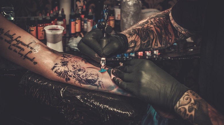 Woman being tattooed on arm