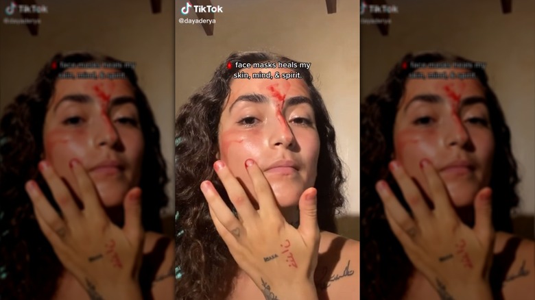 TikTok screenshot of user applying blood to face