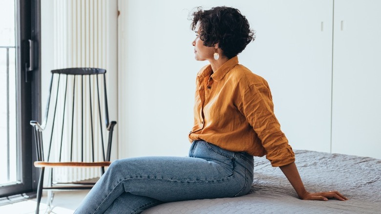 Woman on bed in outside clothes