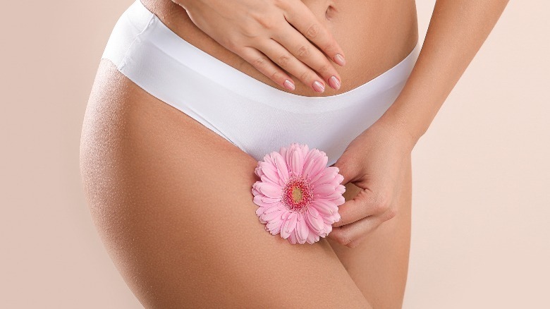 Woman holding flower near underwear