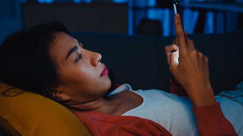 Woman using her phone in bed