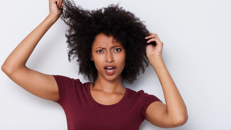 worried woman pulling at curly hair