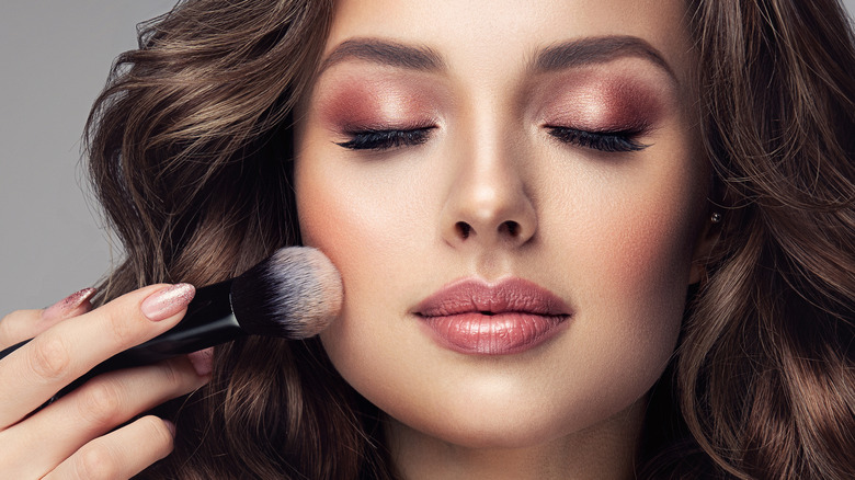 Woman with makeup brush