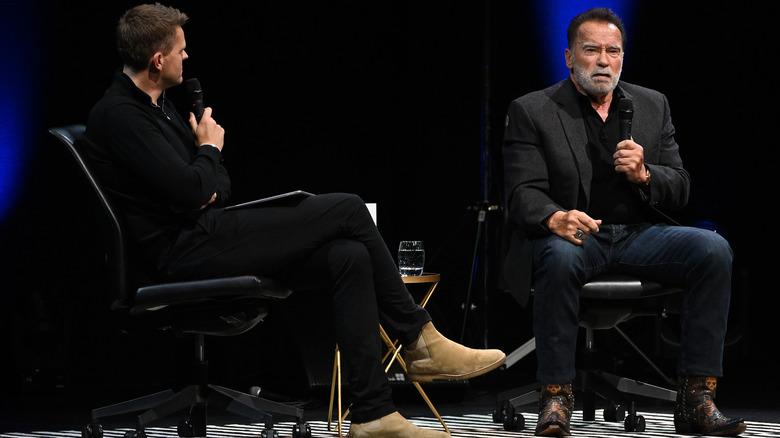 Arnold Schwarzenegger appearing onstage in boots