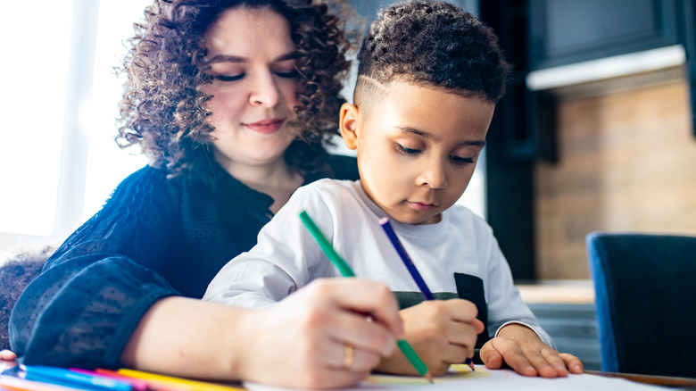 Boy draws with mom