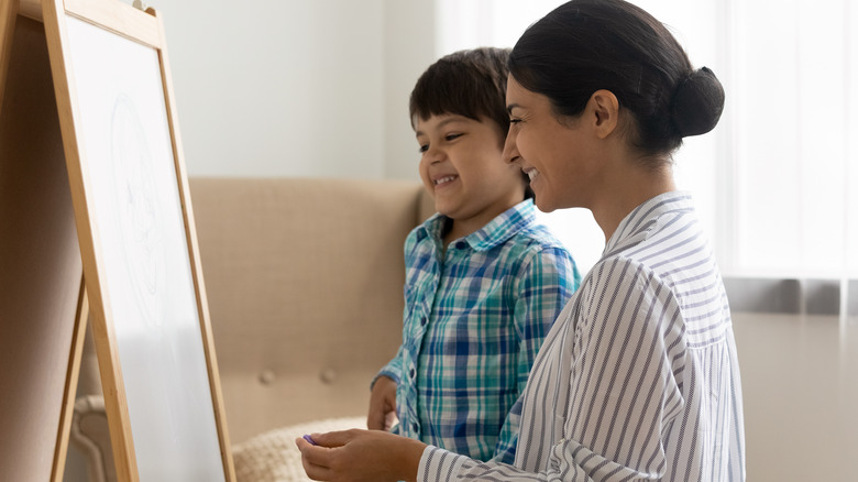 Mom, boy observe canvas