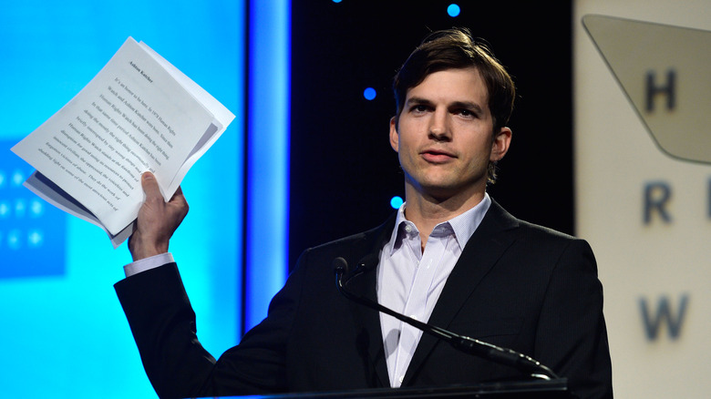 Ashton Kutcher holding papers 