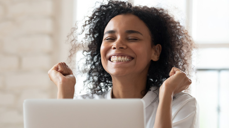 excited woman on computer, smiling 