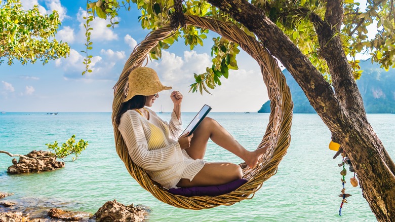 A woman reading on a beach in Thailand 