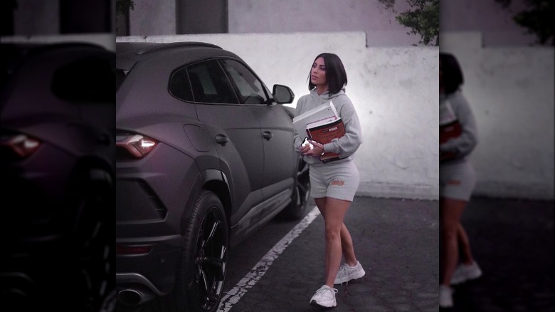 Kim walks near her car