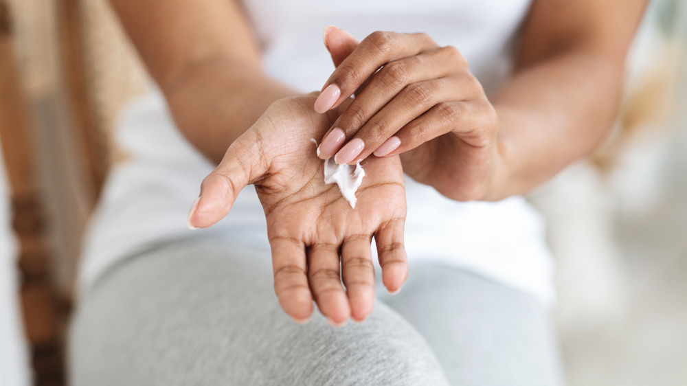 Woman applying lotion to hands