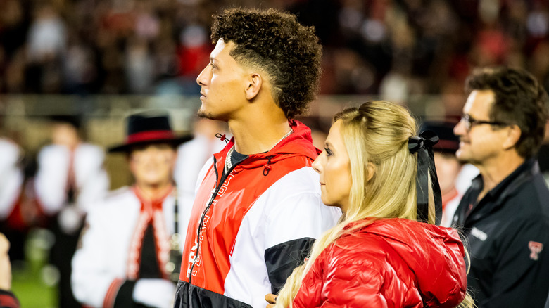 Side profile of Brittany and Patrick Mahomes looking off into the distance among crowd