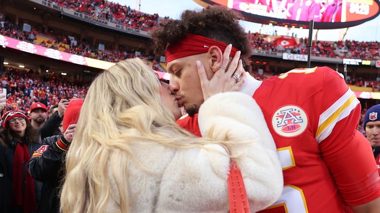 Brittany Mahomes giving Patrick Mahomes a kiss at football game