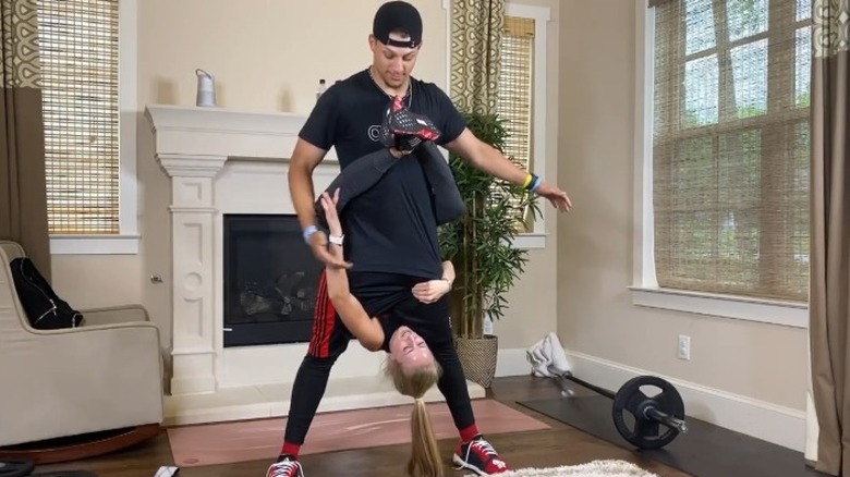 Brittany Mahomes hanging upside while straddling Patrick Mahomes' waist who is standing for the Koala Challenge