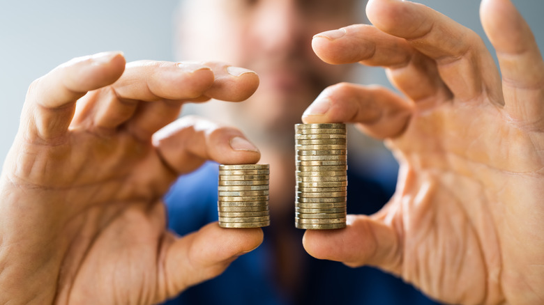 Hands holding unequal stacks of coins