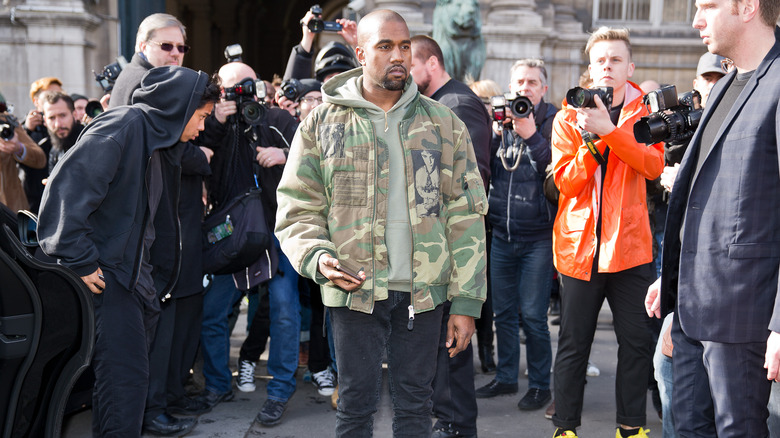 Kanye West surrounded by photographers