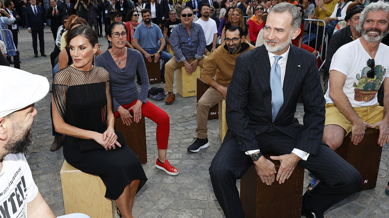 Queen Letizia and King Felipe sitting on cajon