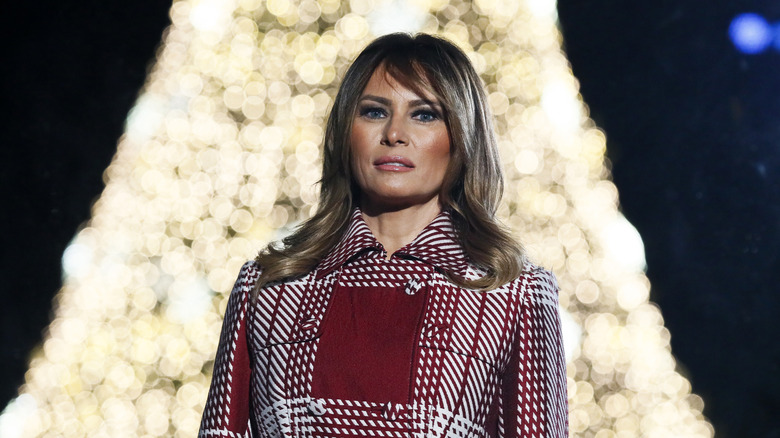 Melania Trump standing in front of tree lights