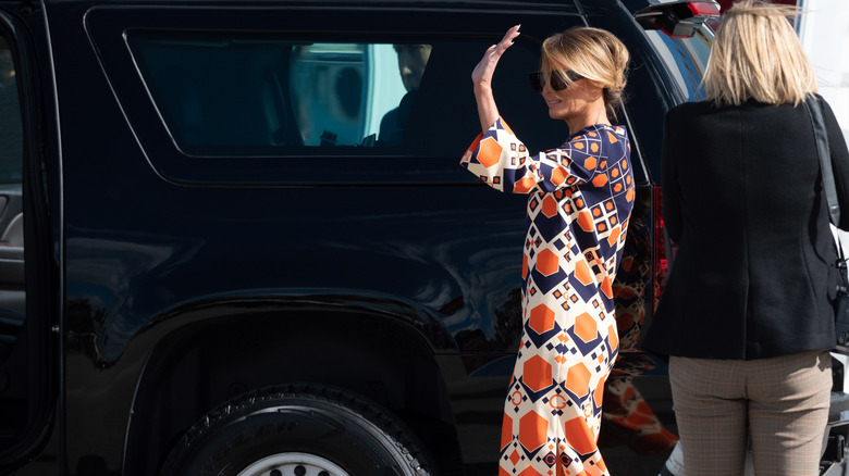 Melania Trump waving while getting into car at airport