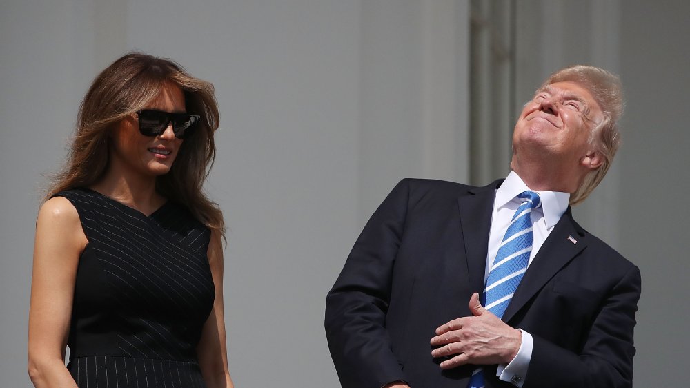 Melania Trump watching Donald Trump looking up at the sky