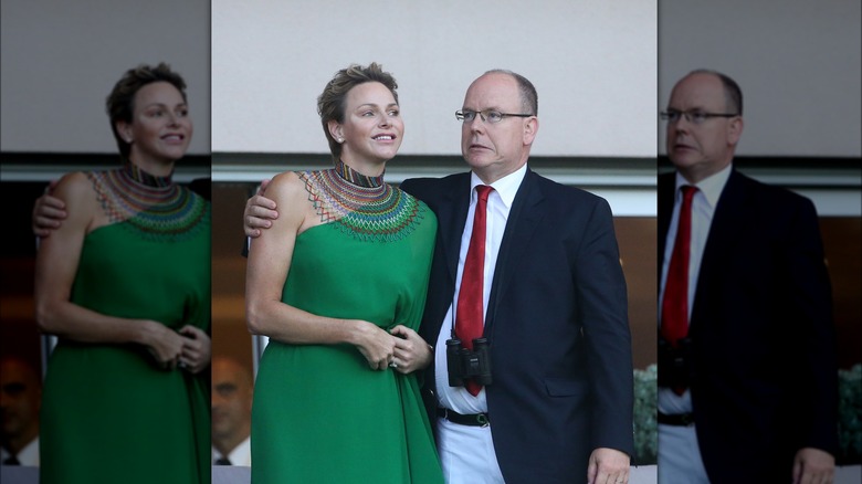 Prince Albert cringing while hugging Princess Charlene