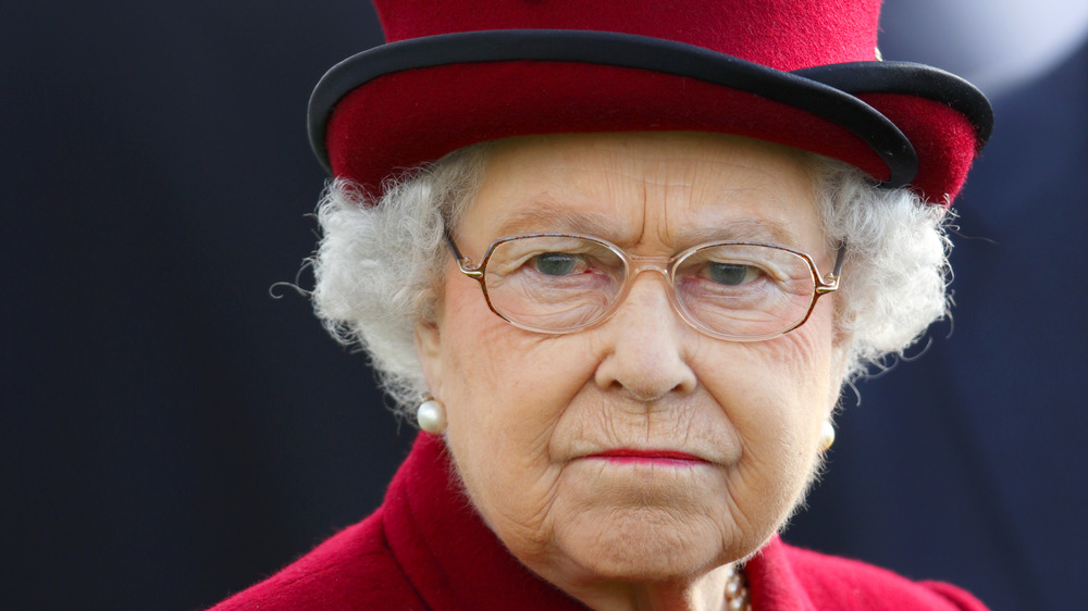 Queen Elizabeth wearing a red hat