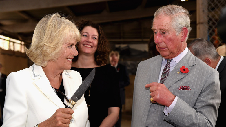 Camilla holding a knife to Charles 