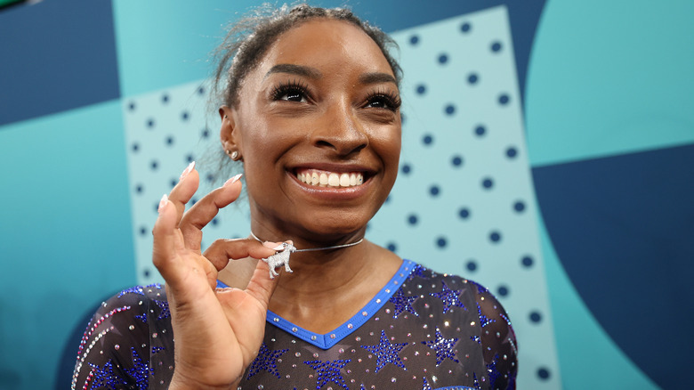 Simone Biles holding her necklace 