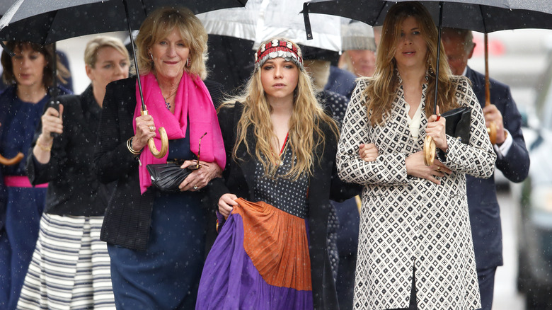 Ayesha Shand walking in rain with crowd